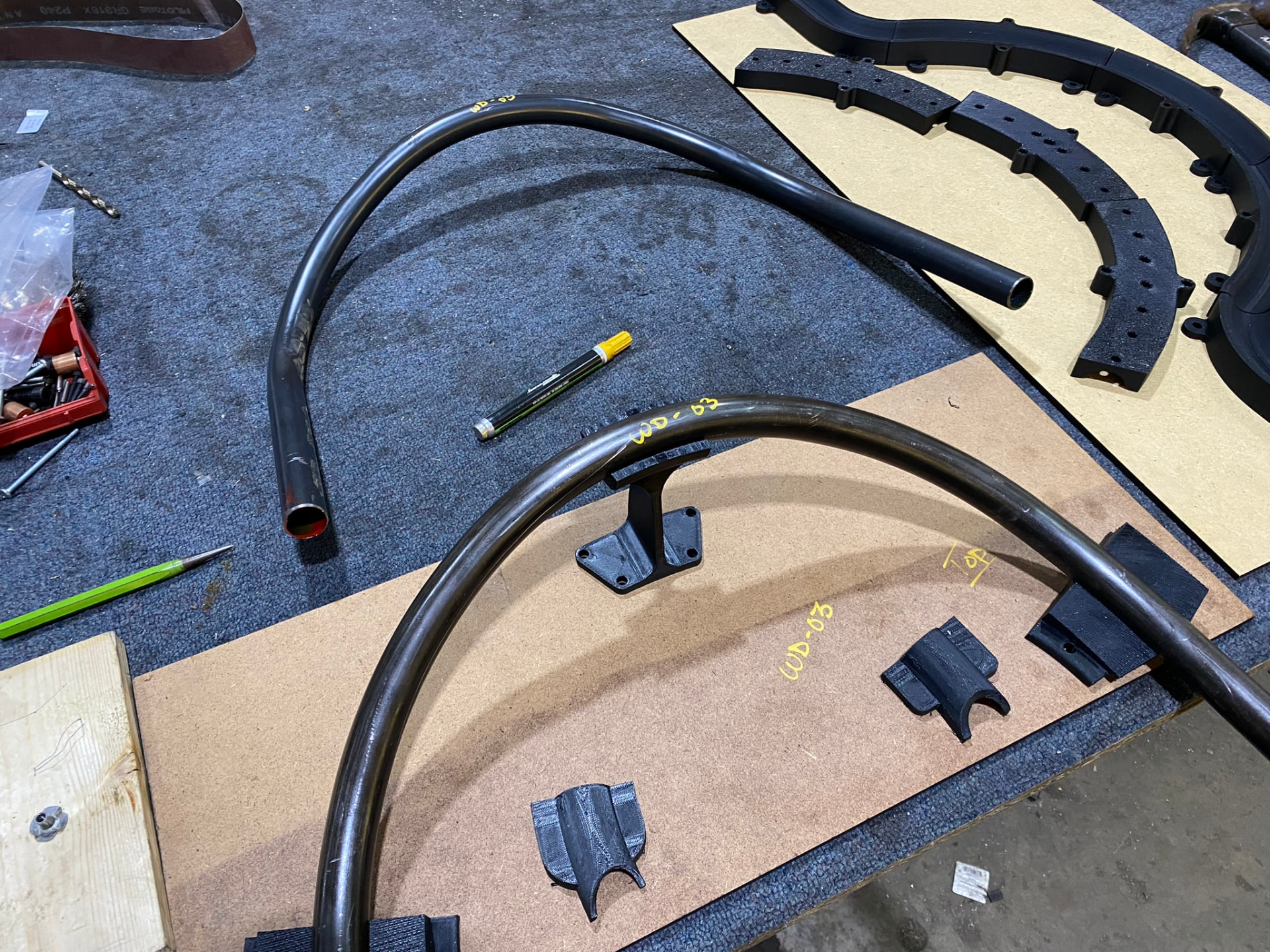 Two bent tube arcs marked WD-03 with matching coping blocks and weld saddles