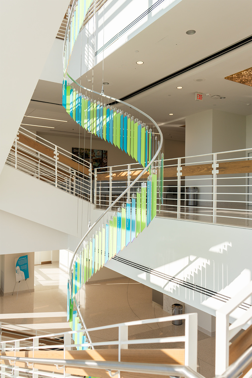 Spiral cascade of engraved donor glass blades descending through the atrium stairwell