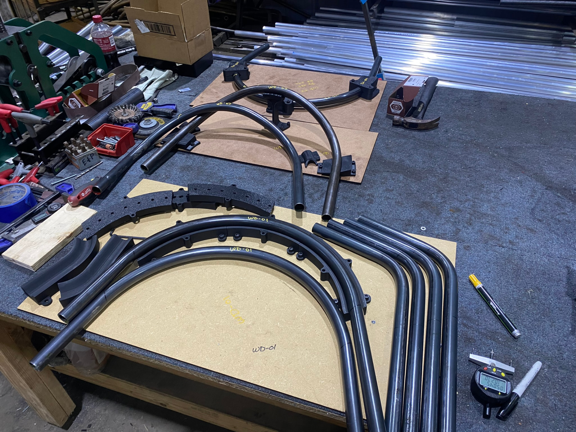 Bent window-display tube arcs staged with coping saddles and layout templates