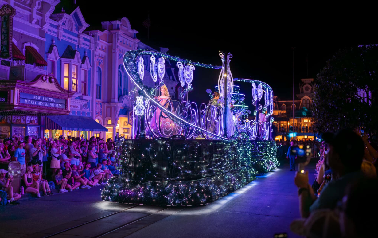 Three-quarter view of the Royal float lit in violet as it moves down the parade route