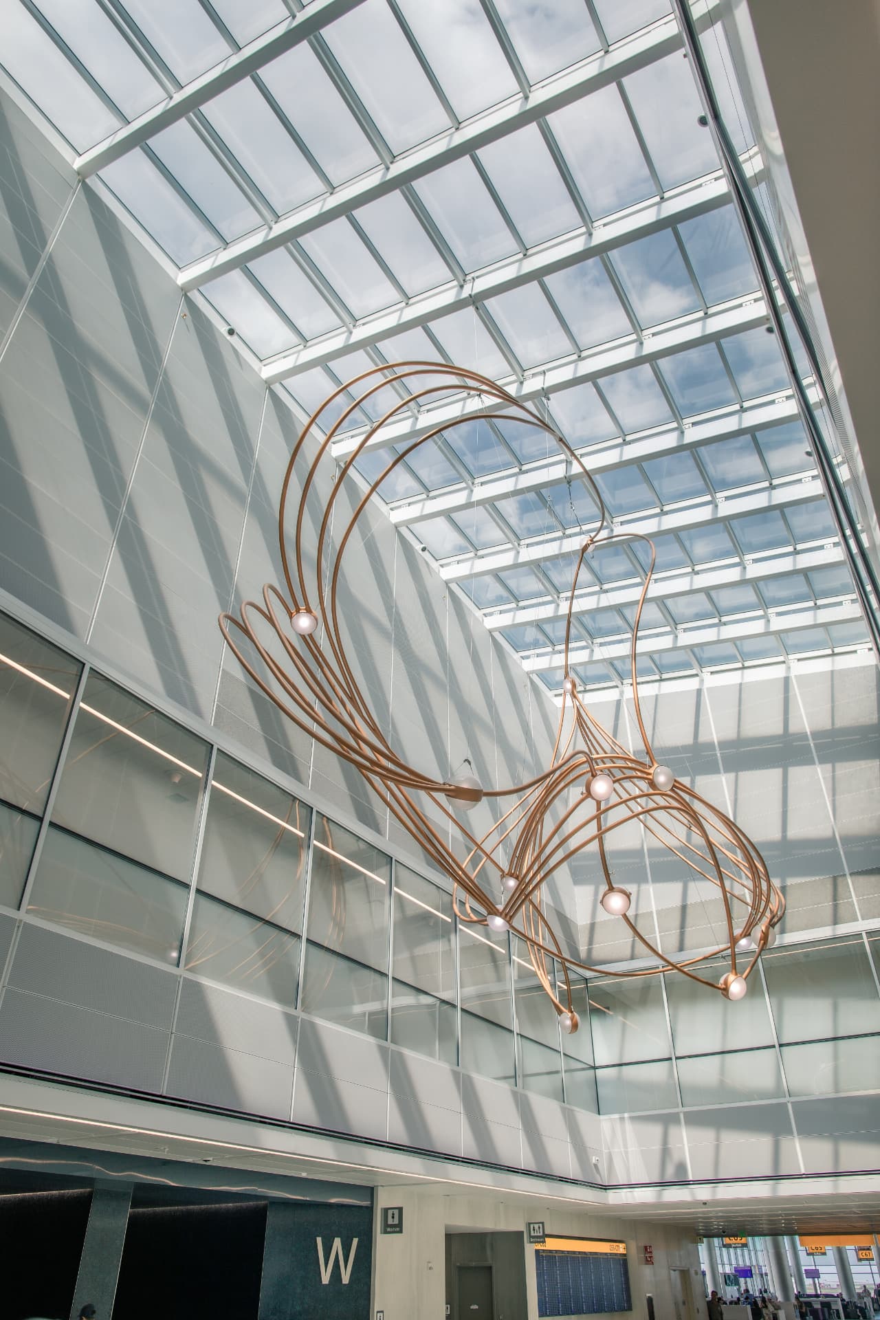 Copper geometry of the sculpture curving beneath the glass roof