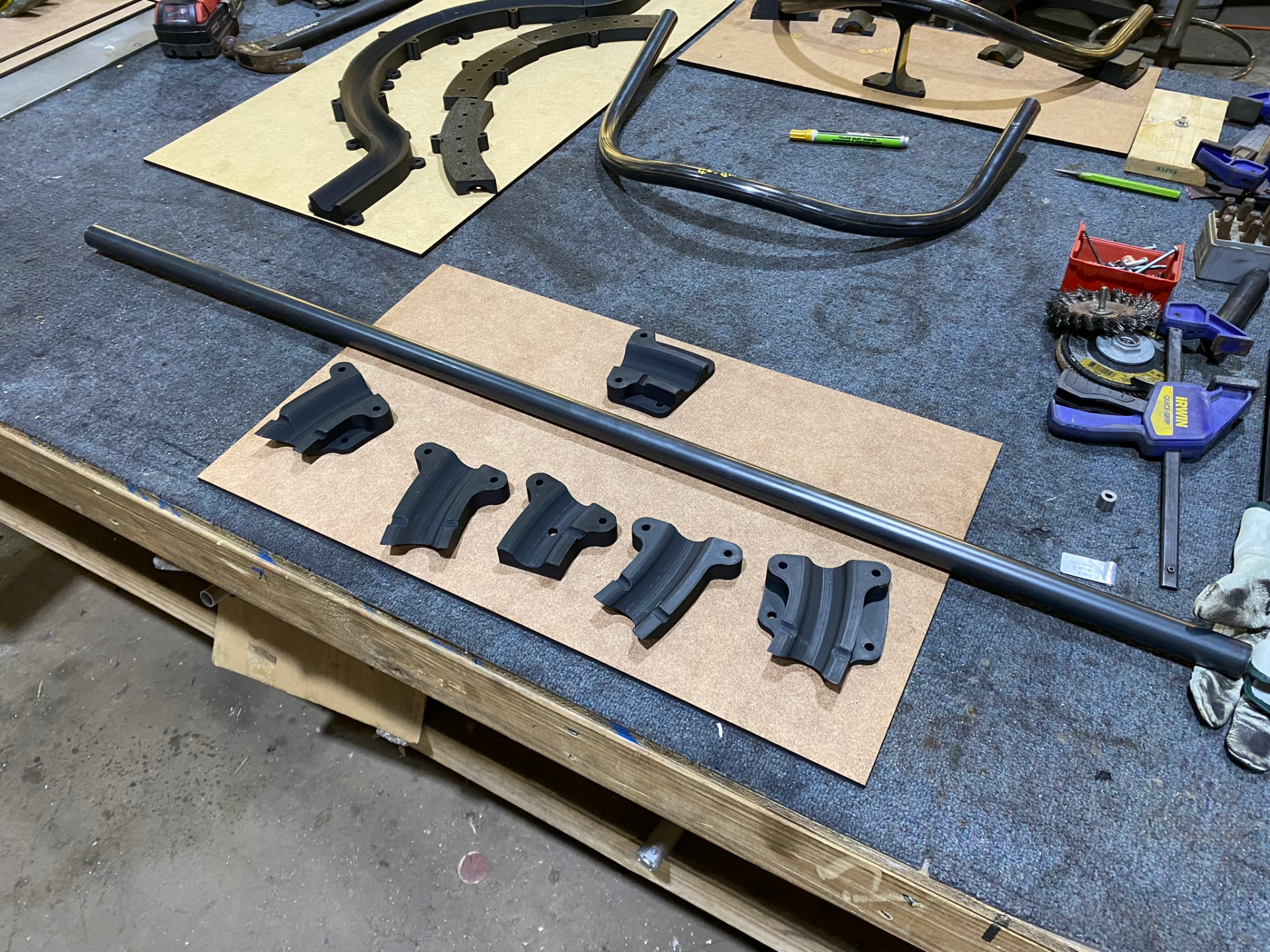 Machined coping saddles laid out beside a straight tube segment on the bench