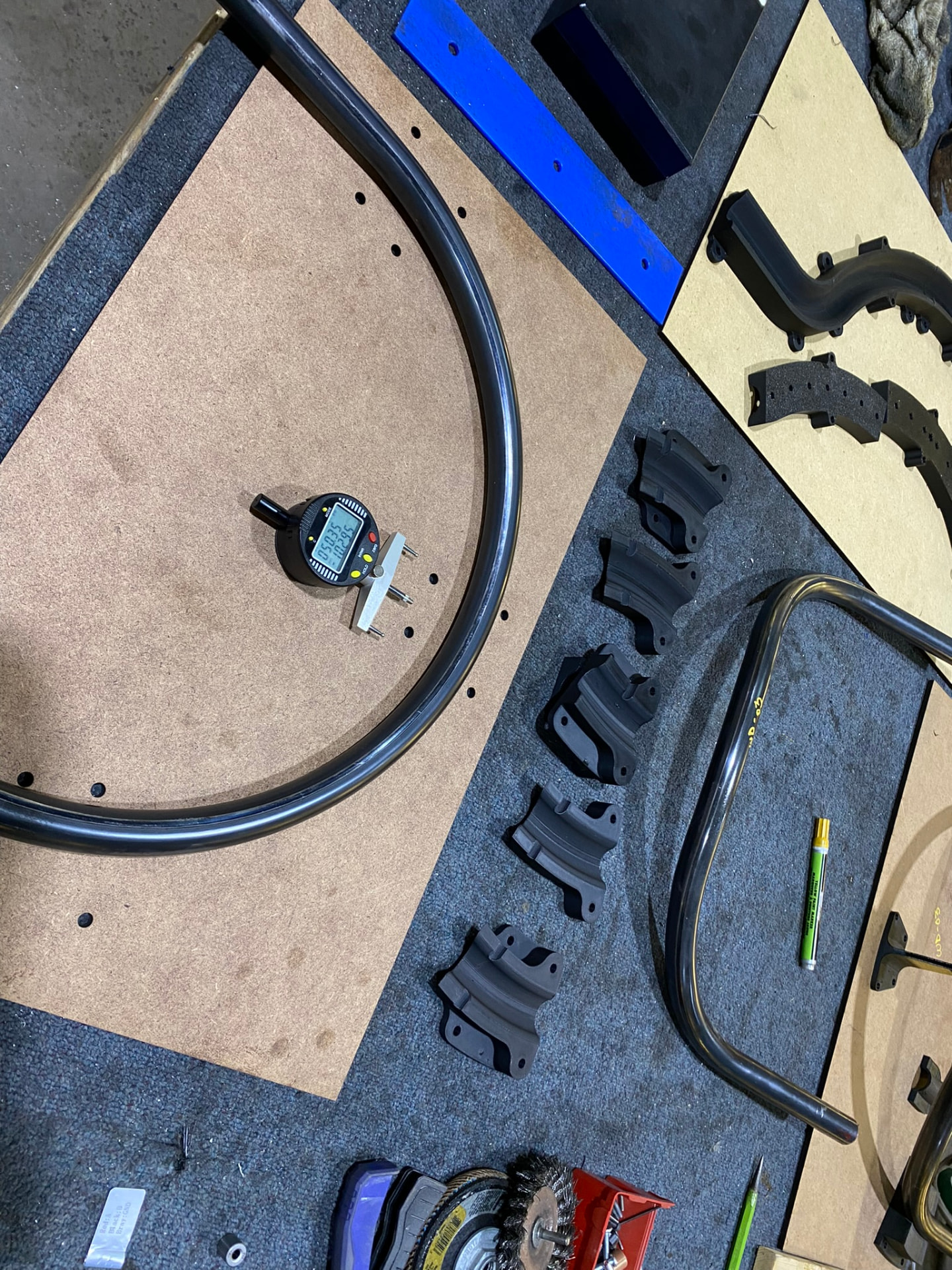 Bent arc checked against a drilled layout template with digital calipers