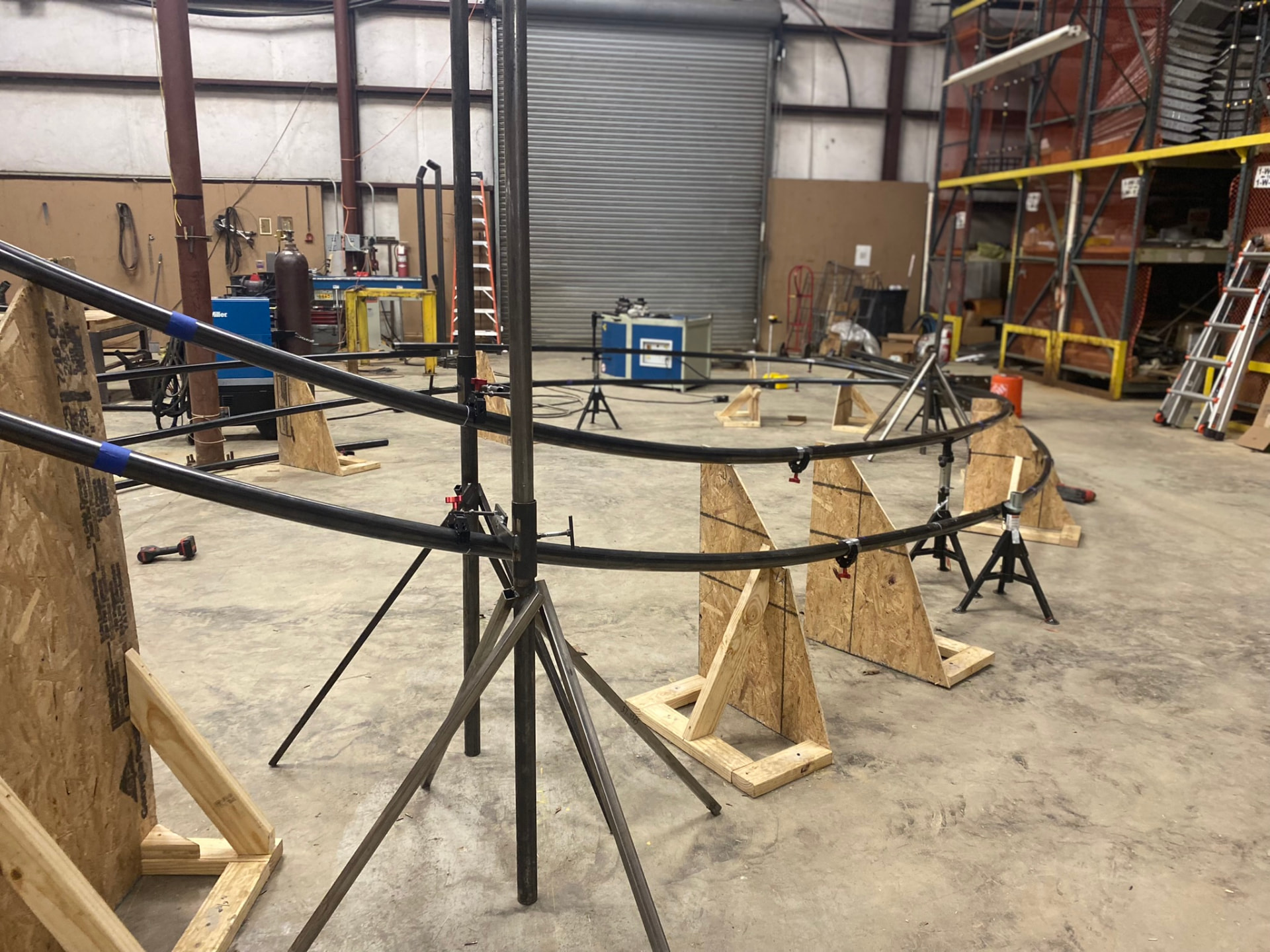 Paired tube runners held in fixture stands, establishing spacing for the internal support plates