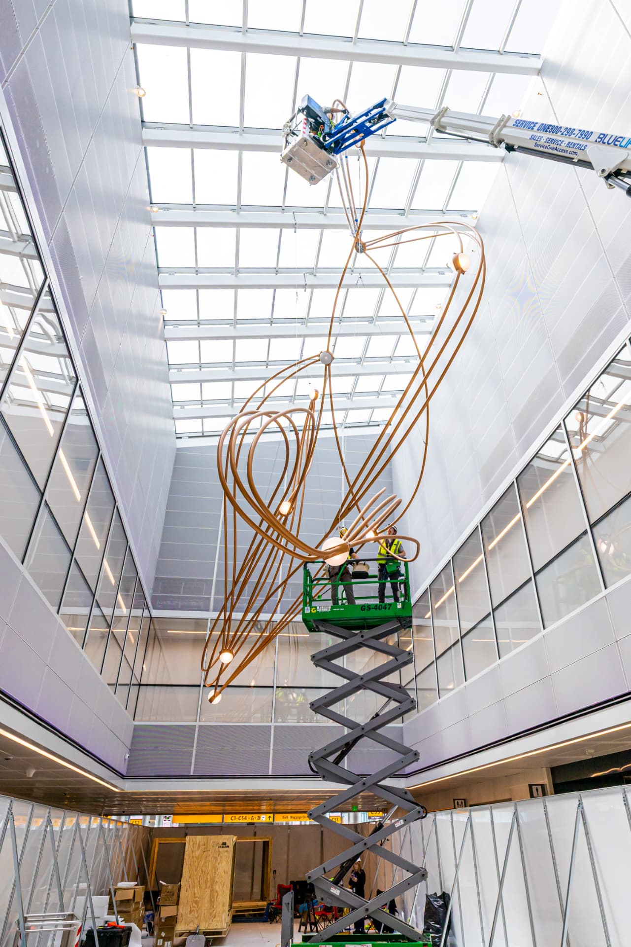 Sculpture section lifted into the atrium by boom and scissor lifts during installation