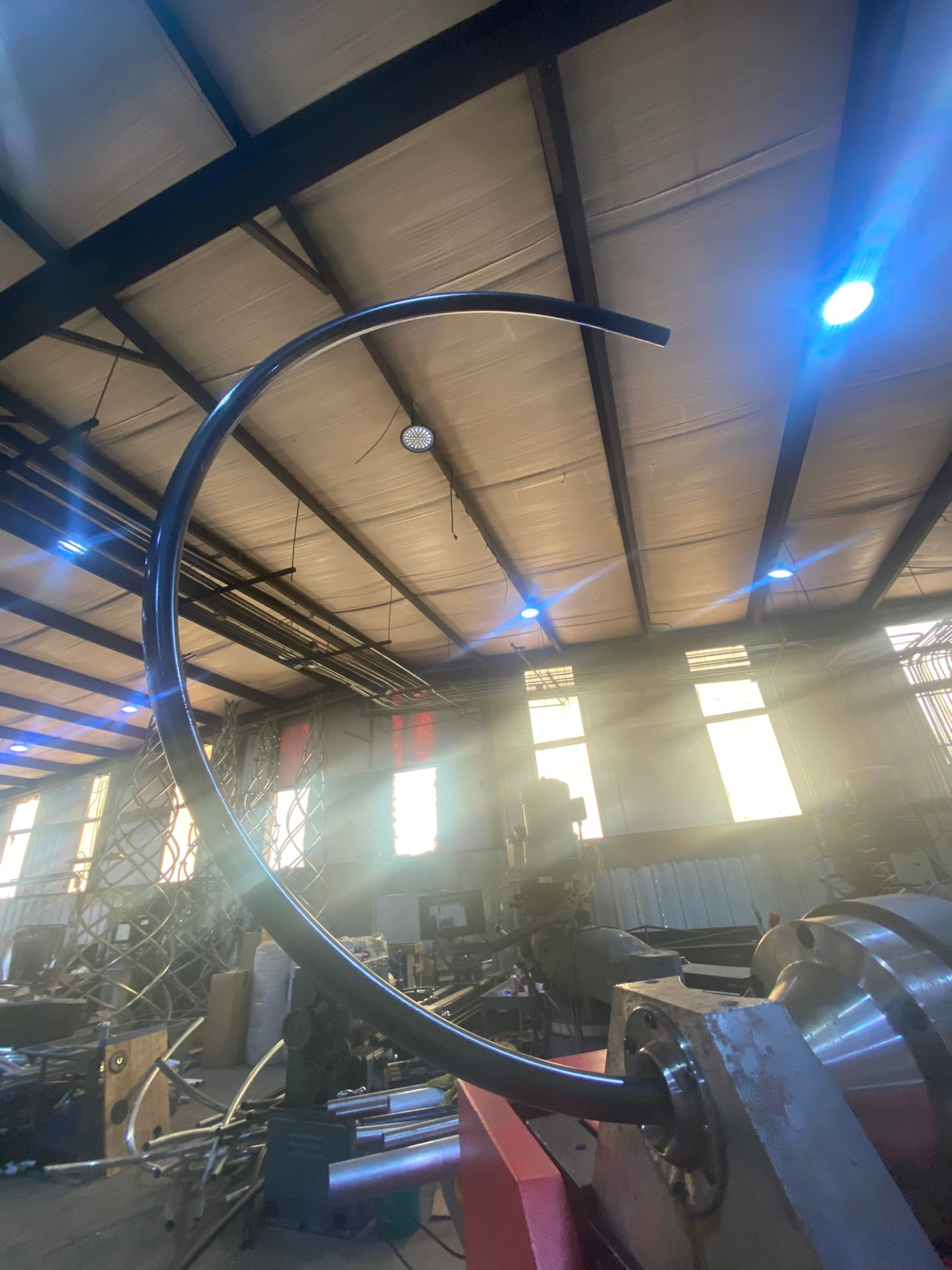 Large-radius bent tube ring backlit in the fabrication shop