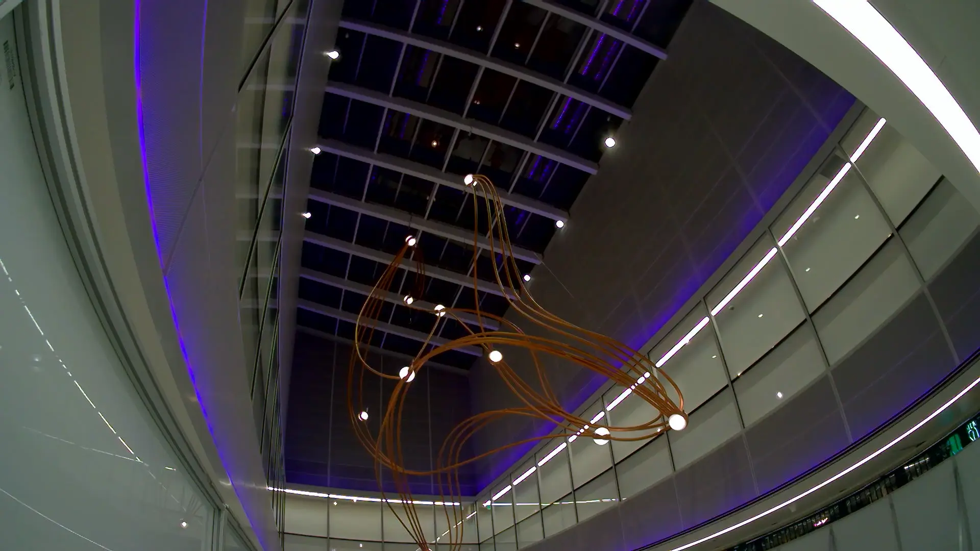 Completed Constellations sculpture suspended beneath the violet-lit atrium skylight